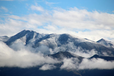 Low angle view of snowcapped mountains against sky