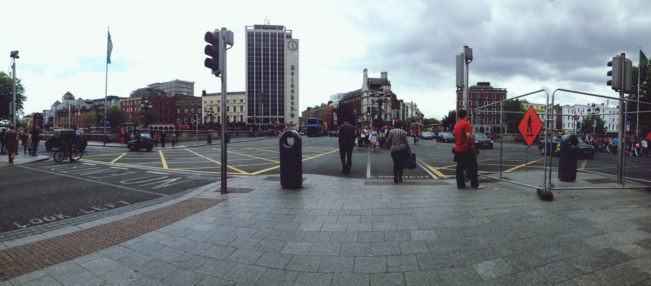 building exterior, architecture, city, built structure, sky, large group of people, men, city life, person, street, cloud - sky, lifestyles, walking, skyscraper, tower, transportation, modern, office building, cityscape