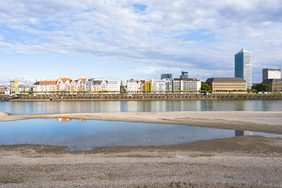 River by buildings against sky in city