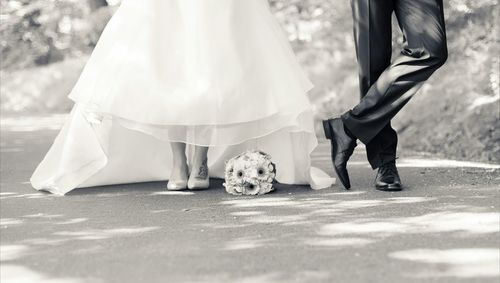 Low section of couple standing on road