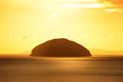 Sunset at ailsa crag, aka paddy's milestone, viewed from the coast of girvan, scotland