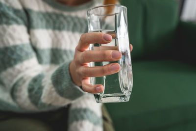 Midsection of woman holding wineglass