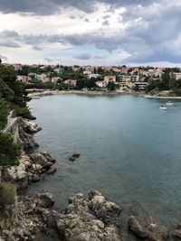 Scenic view of sea by city against sky