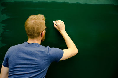Rear view of man standing against lake