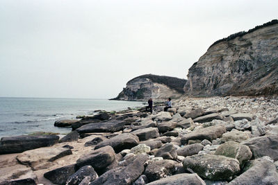 Rocks on beach against clear sky