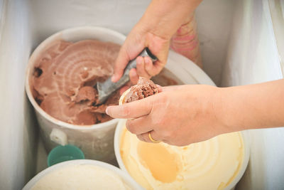 The woman's hand scooping the ice cream