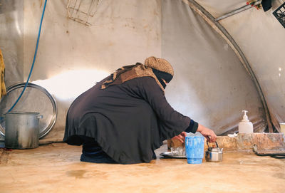 Rear view of young woman sitting on table