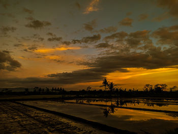 Scenic view of lake against orange sky