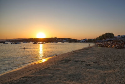 Scenic view of beach against clear sky during sunset