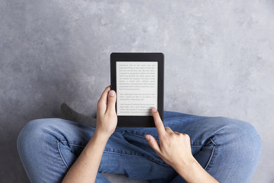 Midsection of man using mobile phone on sofa