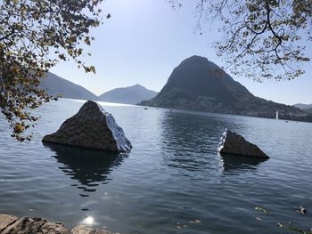 Scenic view of lake by mountains against clear sky