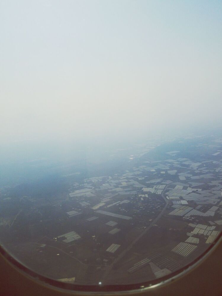 aerial view, airplane, transportation, landscape, air vehicle, window, scenics, mode of transport, vehicle interior, copy space, fog, sky, transparent, nature, glass - material, beauty in nature, aircraft wing, weather, travel