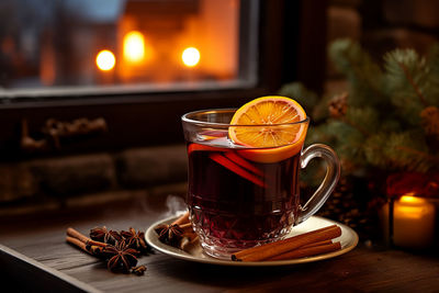 Cup of autumn or winter mulled wine or gluhwein with spices and orange slices