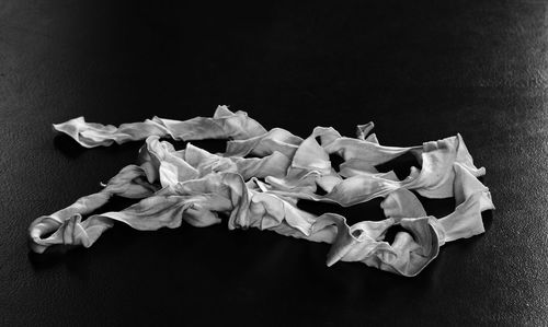 Close-up of wilted flowers on table against black background