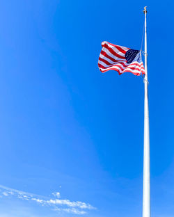 Low angle view of flag against blue sky