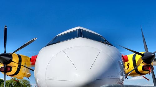 Low angle view of airplane against clear blue sky