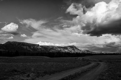 Country road against cloudy sky