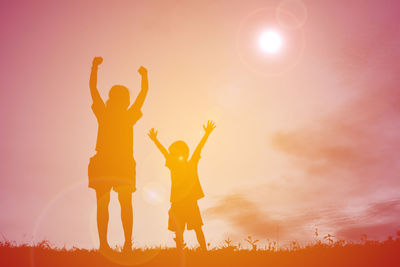 Low angle view of woman hands against sky during sunset