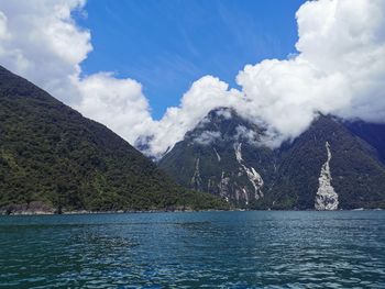 Scenic view of lake by mountains against sky