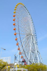 Low angle view of ferris wheel against blue sky