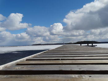 Surface level of pier over sea against sky