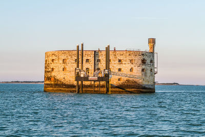 View of building by sea against clear sky