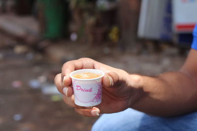 Close-up of hand holding coffee cup