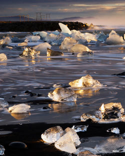 Ice floating on sea during sunset