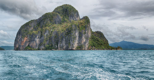 Scenic view of rock formation in sea against sky