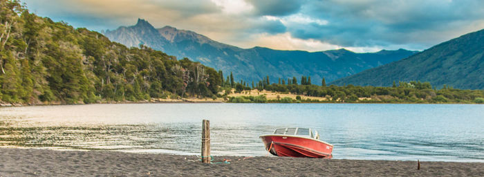 Scenic view of lake by mountains against sky