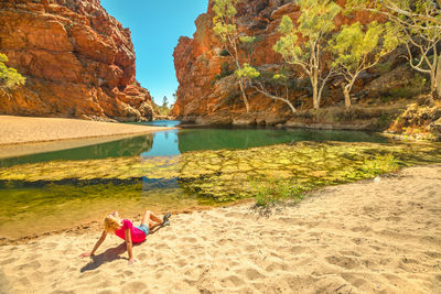 People on beach by rock formation