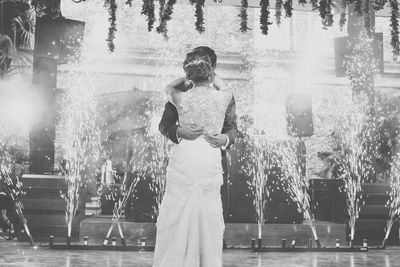 Wedding couple dancing against fireworks at night