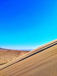 Scenic view of desert against clear blue sky