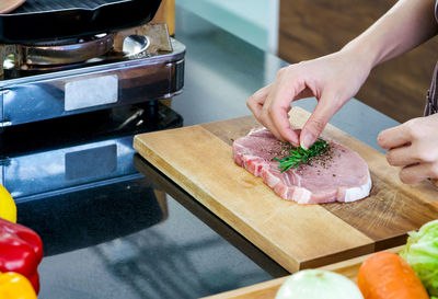 Midsection of person preparing food on cutting board