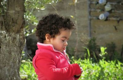 Close-up of boy against tree trunk