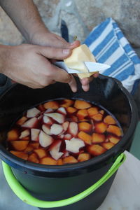 Cropped image of person holding food in kitchen