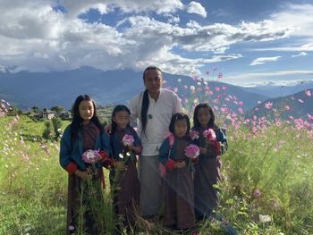 Rear view of woman standing on field against sky