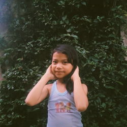 Portrait of girl standing against trees