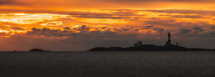 Scenic view of sea against dramatic sky during sunset