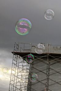 Low angle view of bubbles against sky