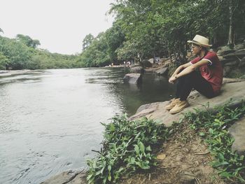 Woman by lake against trees