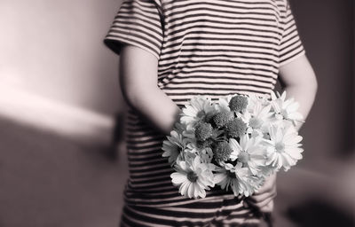 Midsection of woman holding flower bouquet