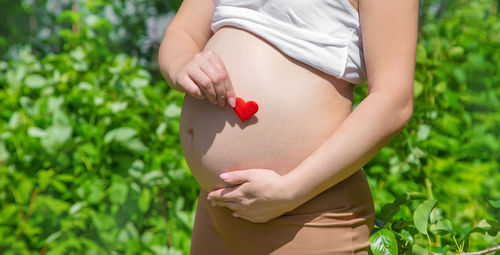 Pregnant woman holding heart shape