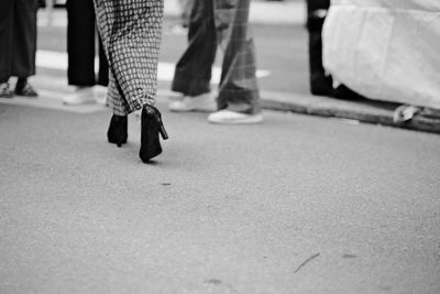 Low section of woman walking on street