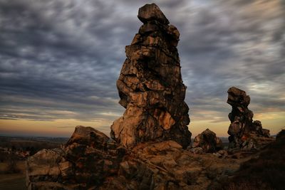 View of rock formations against cloudy sky