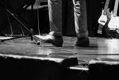 Low section of man standing on guitar