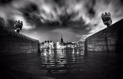 Statue in city against cloudy sky