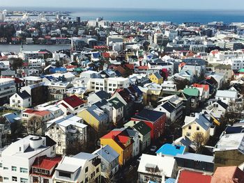 High angle view of townscape by sea against sky