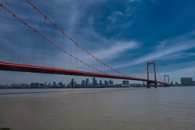 View of suspension bridge against cloudy sky