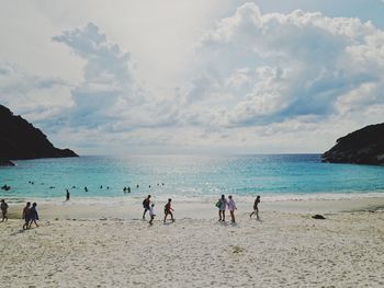 People on beach against sky